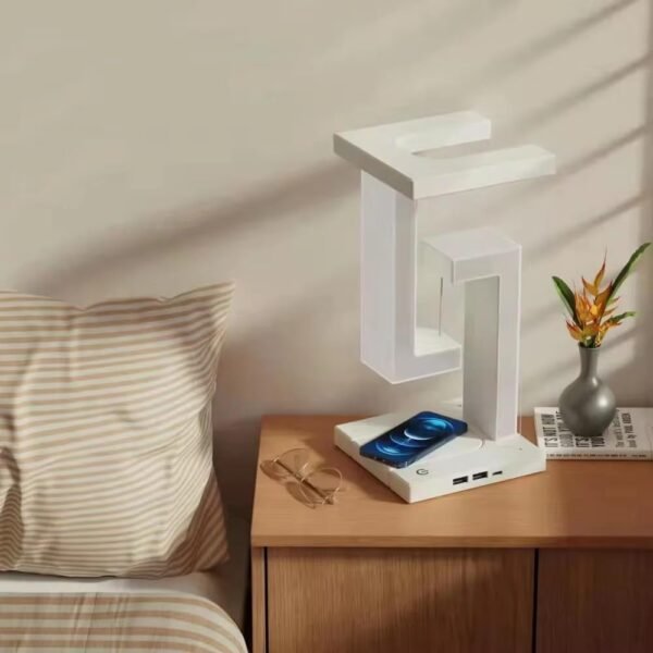 A white phone charger rests on a nightstand beside a neatly made bed, ready for use during the night.